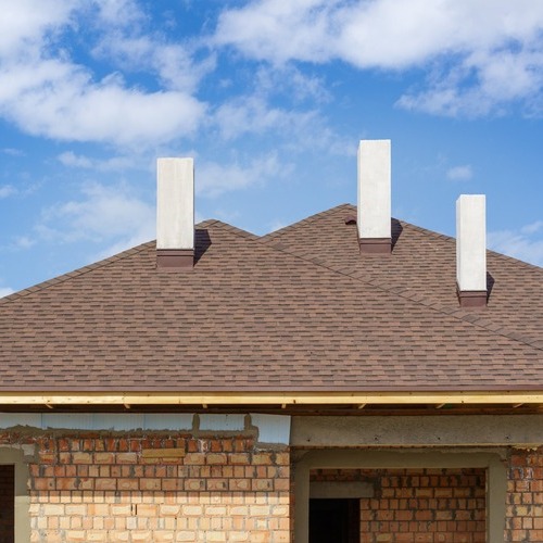 asphalt shingle roof with three white chimneys