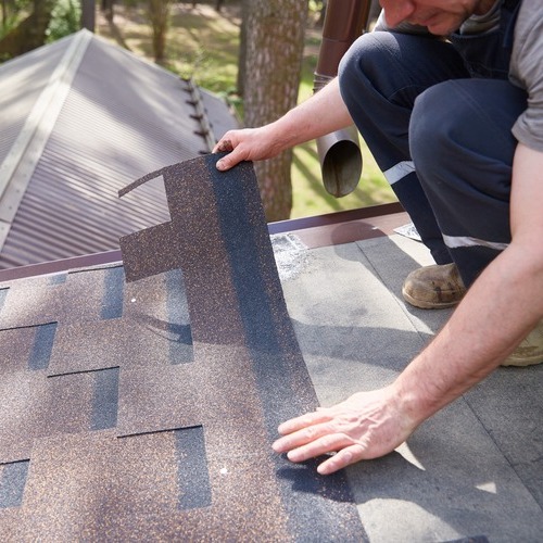 a roofer installing shingles