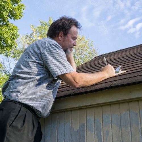 insurance adjuster examining a roof