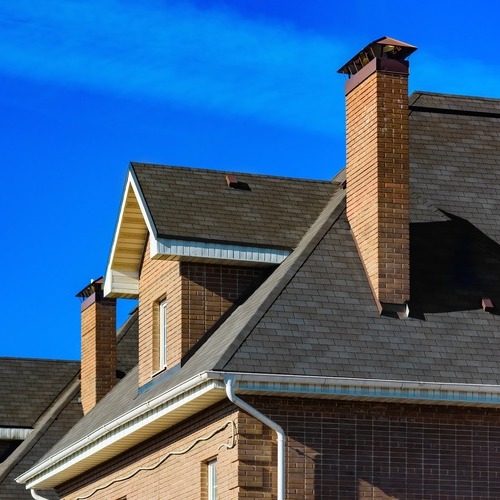 home with a chimney and a shingle roof