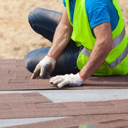 a worker installing roofing shingles