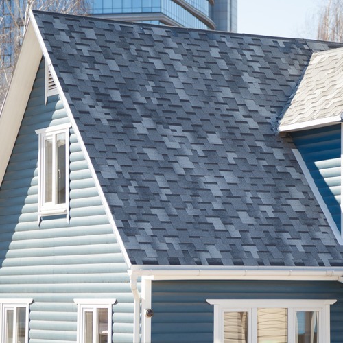 a blue and white home with a shingle roof